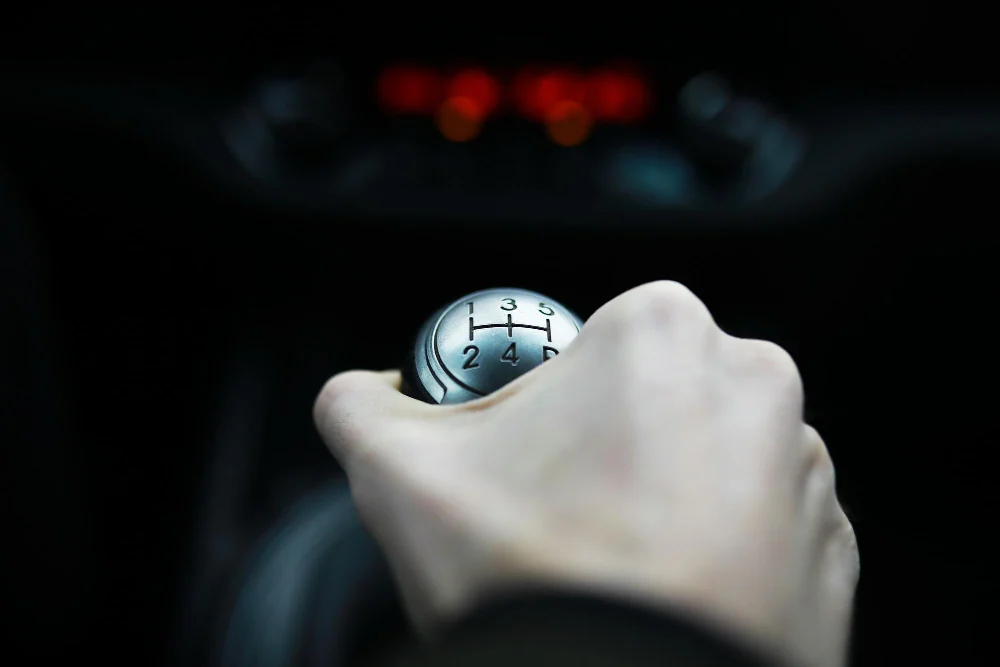 Person prøver at skifte gear på defekt bil